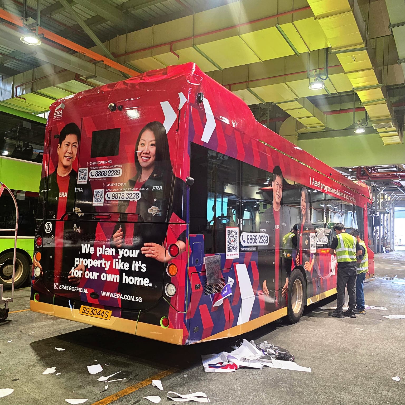 Christopher Ng and Jasmine Chan beside their ERA-wrapped SBS Transit bus SG3044S in Singapore