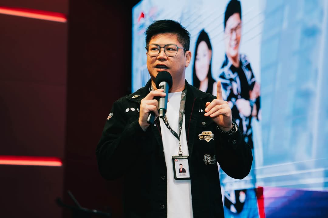 Christopher Ng speaking on stage at a real estate investor masterclass in Singapore